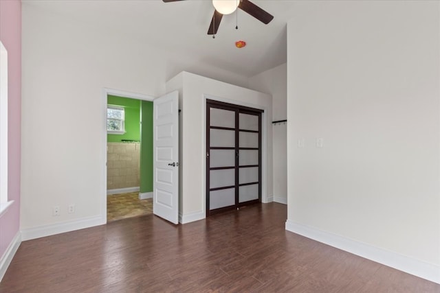 unfurnished bedroom featuring ceiling fan and dark hardwood / wood-style flooring