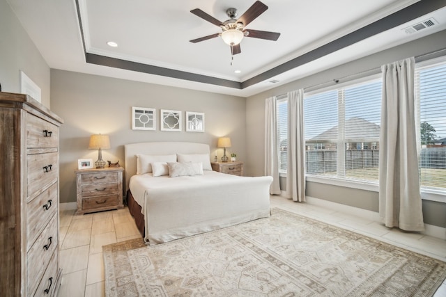 bedroom with ornamental molding, ceiling fan, and a tray ceiling