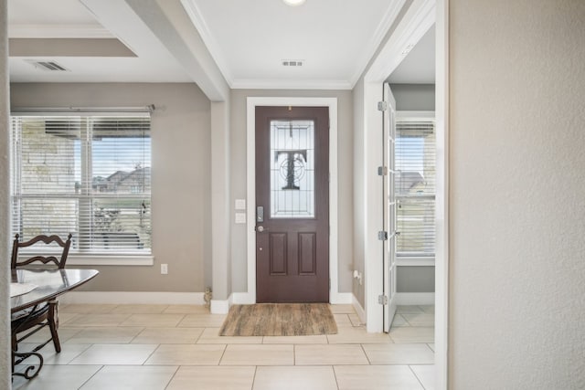 foyer featuring a wealth of natural light and crown molding