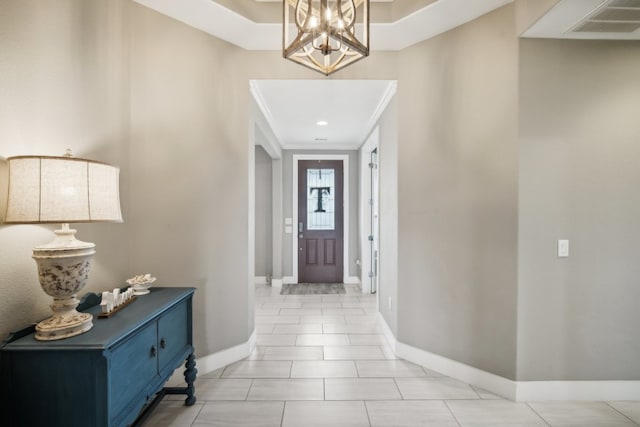 entrance foyer featuring light tile patterned flooring, crown molding, and an inviting chandelier