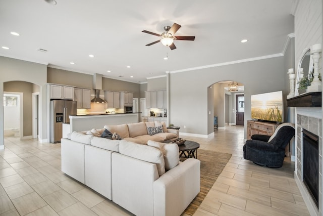 living room with ceiling fan with notable chandelier and crown molding