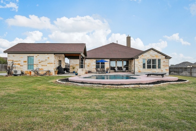 rear view of house featuring a patio, a yard, and a fenced in pool