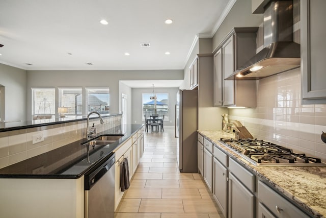 kitchen with ornamental molding, appliances with stainless steel finishes, gray cabinets, sink, and wall chimney exhaust hood