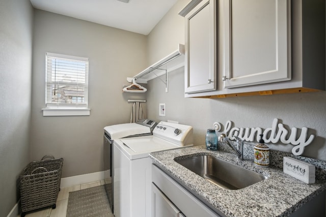 washroom with washing machine and dryer, cabinets, sink, and light tile patterned floors