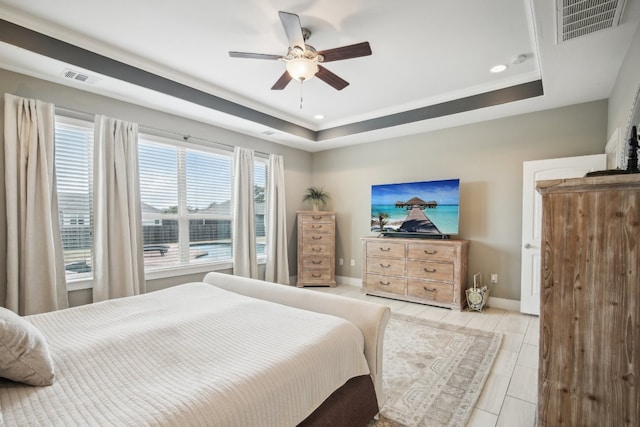 tiled bedroom featuring ceiling fan and a raised ceiling