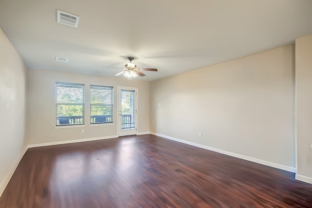 unfurnished room with ceiling fan, baseboards, visible vents, and dark wood finished floors