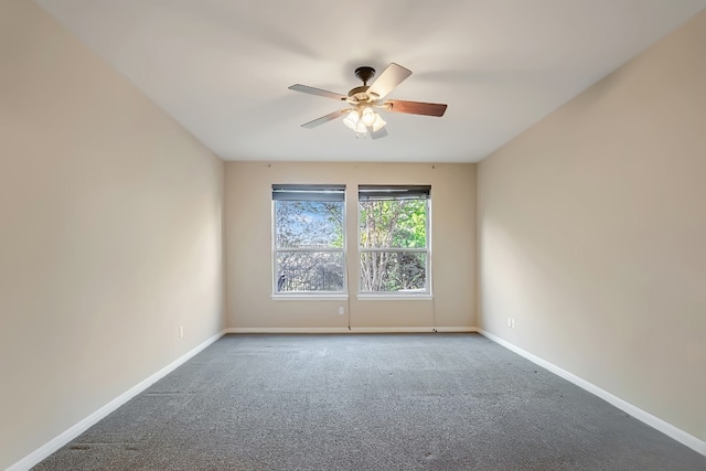 carpeted spare room with a ceiling fan and baseboards