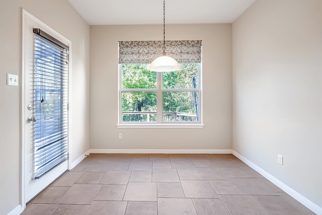 unfurnished dining area featuring baseboards and light tile patterned floors