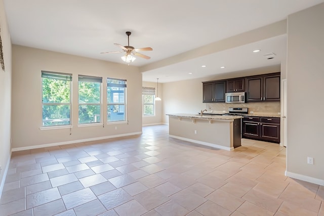 kitchen with a breakfast bar, decorative backsplash, a healthy amount of sunlight, and stainless steel appliances