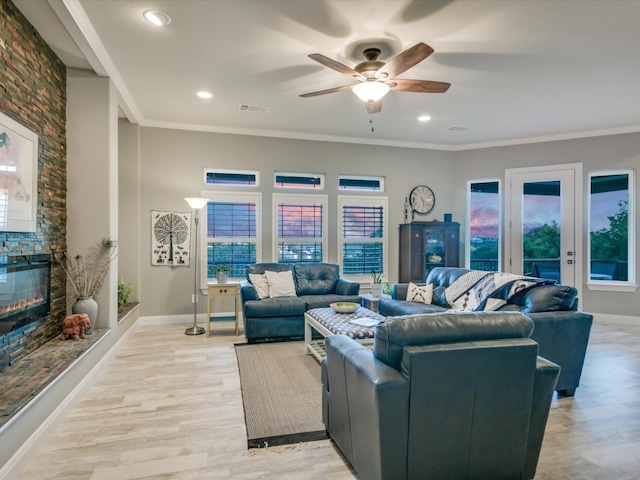 living room featuring light hardwood / wood-style floors, plenty of natural light, crown molding, and ceiling fan