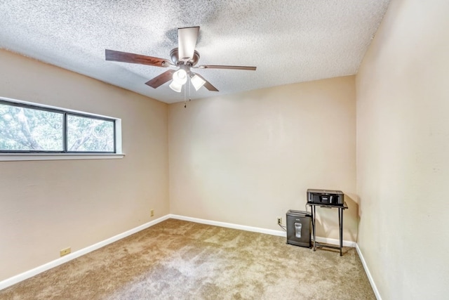 unfurnished room with ceiling fan, light colored carpet, and a textured ceiling