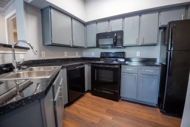 kitchen with light hardwood / wood-style floors, sink, black appliances, and gray cabinets