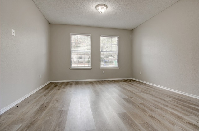 unfurnished room with light hardwood / wood-style floors and a textured ceiling