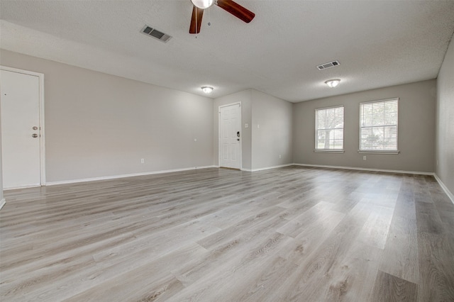 unfurnished room with light wood-type flooring, a textured ceiling, and ceiling fan