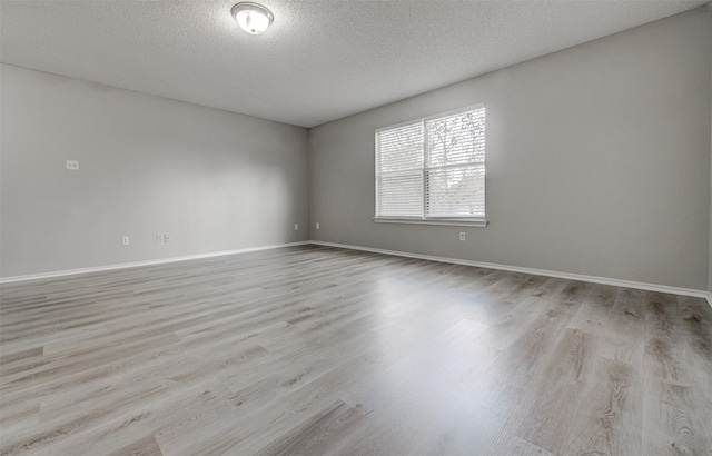 unfurnished room with light hardwood / wood-style floors and a textured ceiling