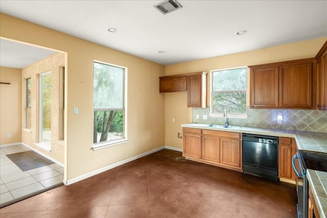 kitchen with brown cabinets, black dishwasher, visible vents, and tile countertops