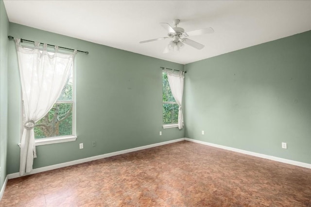 unfurnished room featuring a ceiling fan, a healthy amount of sunlight, and baseboards