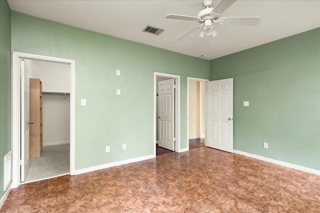 unfurnished bedroom featuring ceiling fan, visible vents, baseboards, a spacious closet, and a closet