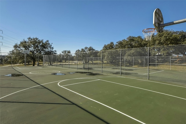 view of basketball court featuring a tennis court, community basketball court, and fence