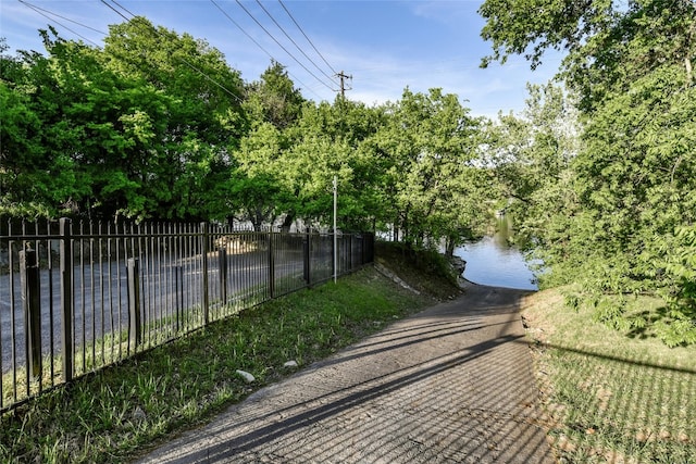 exterior space with a water view and fence