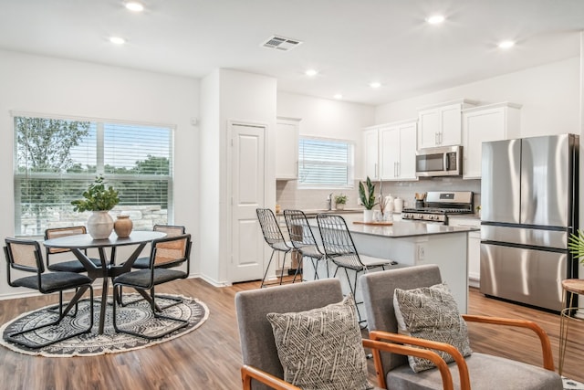 kitchen featuring white cabinets, a kitchen island, a healthy amount of sunlight, and stainless steel appliances