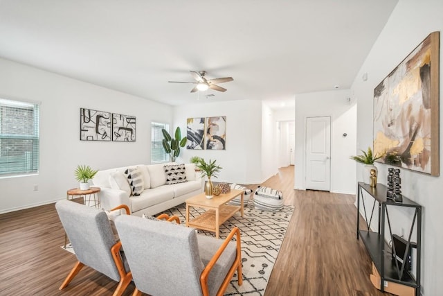 living room with plenty of natural light, ceiling fan, and dark wood-type flooring