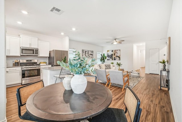 dining area with ceiling fan and light hardwood / wood-style floors