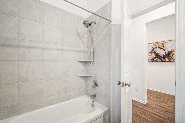 bathroom featuring hardwood / wood-style floors, tiled shower / bath, and ornamental molding