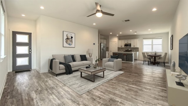 living room featuring hardwood / wood-style floors and ceiling fan