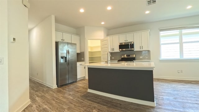 kitchen with white cabinets, stainless steel appliances, and a center island with sink