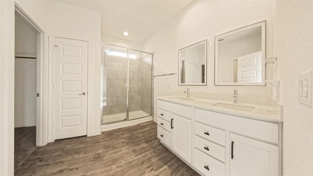 bathroom featuring hardwood / wood-style floors, vanity, and a shower with shower door