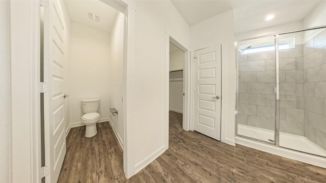 bathroom featuring wood-type flooring, toilet, and walk in shower