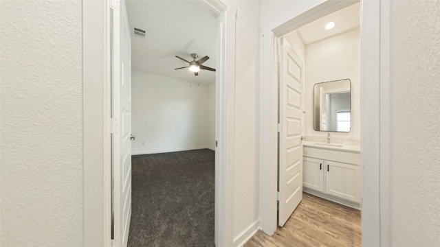 hallway featuring light wood-type flooring and sink