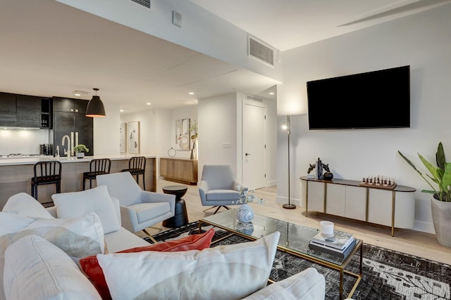 living room featuring light hardwood / wood-style floors and sink