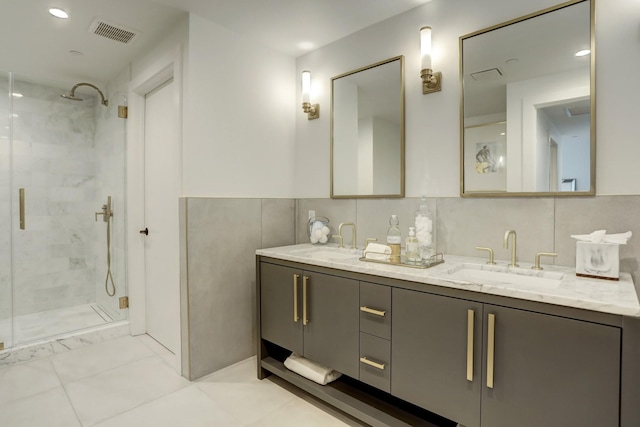 bathroom featuring tasteful backsplash, vanity, tile patterned floors, and a shower with door