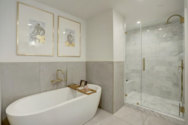 bathroom with separate shower and tub, tile walls, and tile patterned floors