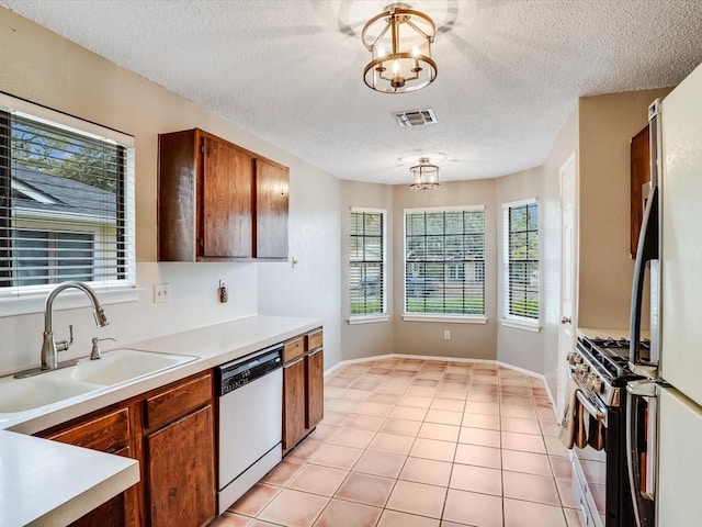 3606 Lovage Dr, Austin, TX 78727 - kitchen with dishwasher, gas stove, a textured ceiling, light countertops, and a chandelier