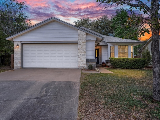 single story home with a garage and a lawn