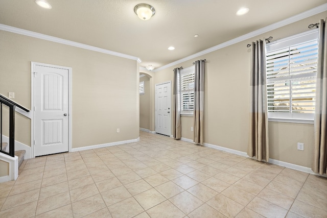 spare room featuring light tile patterned floors and crown molding