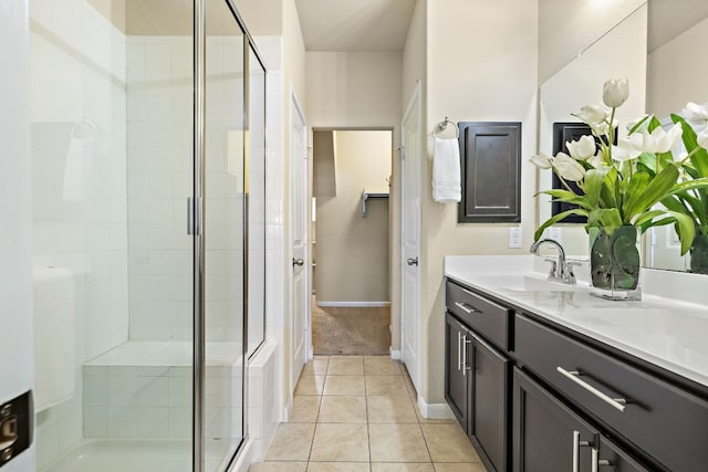 bathroom featuring tile patterned flooring, vanity, and a shower with shower door