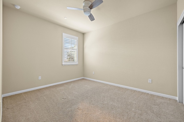 carpeted empty room featuring ceiling fan