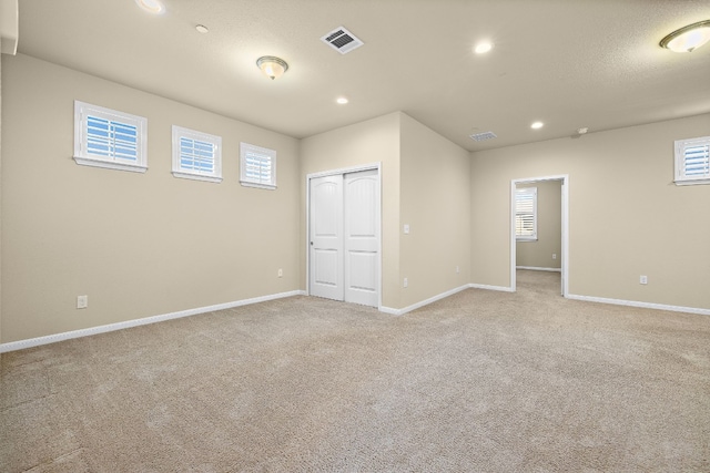 spare room featuring light colored carpet