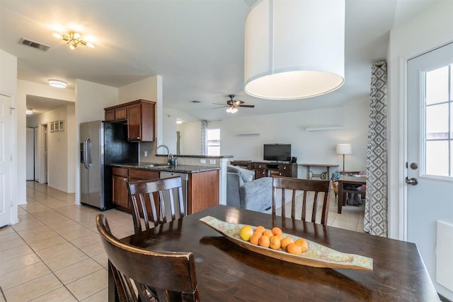 tiled dining space featuring ceiling fan and sink