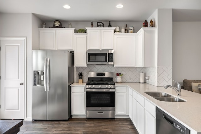 kitchen featuring white cabinets, decorative backsplash, sink, and appliances with stainless steel finishes