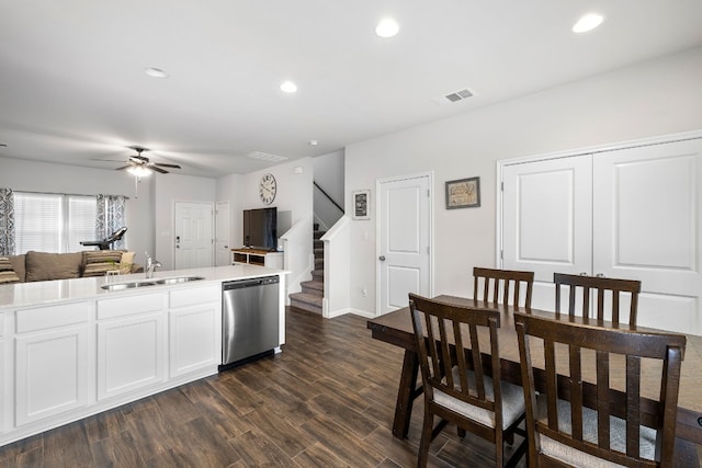 kitchen featuring dishwasher, sink, white cabinets, ceiling fan, and dark wood-type flooring