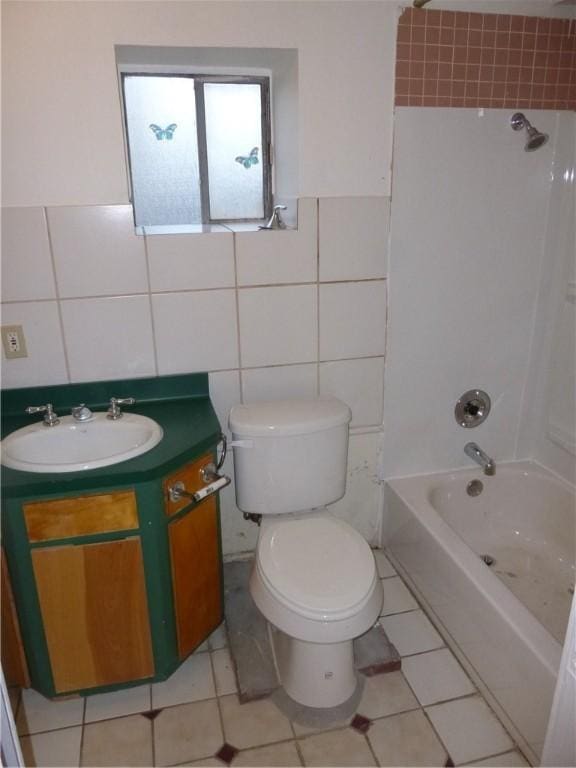 7403 Guadalupe St, Austin, TX 78752 - full bath featuring tile walls, vanity, toilet, washtub / shower combination, and tile patterned floors