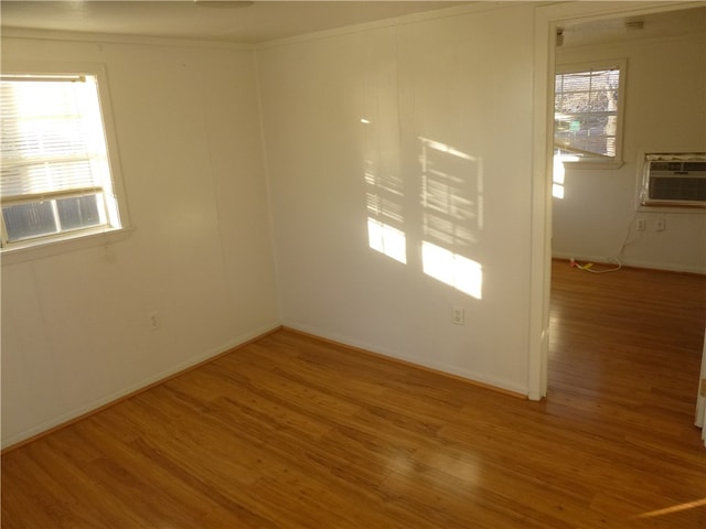 spare room with cooling unit and light hardwood / wood-style floors