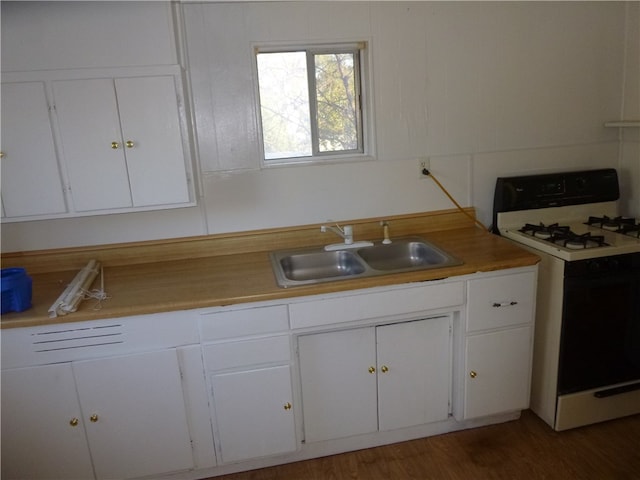 kitchen with gas range gas stove, white cabinetry, sink, and dark wood-type flooring