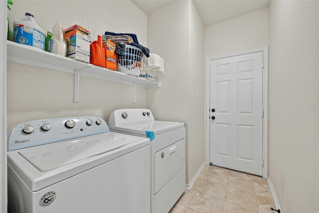 laundry area featuring light tile patterned flooring and washer and clothes dryer