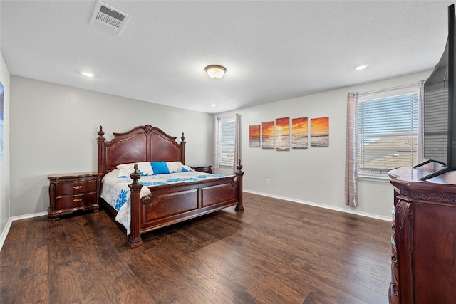 bedroom with a textured ceiling and dark hardwood / wood-style floors